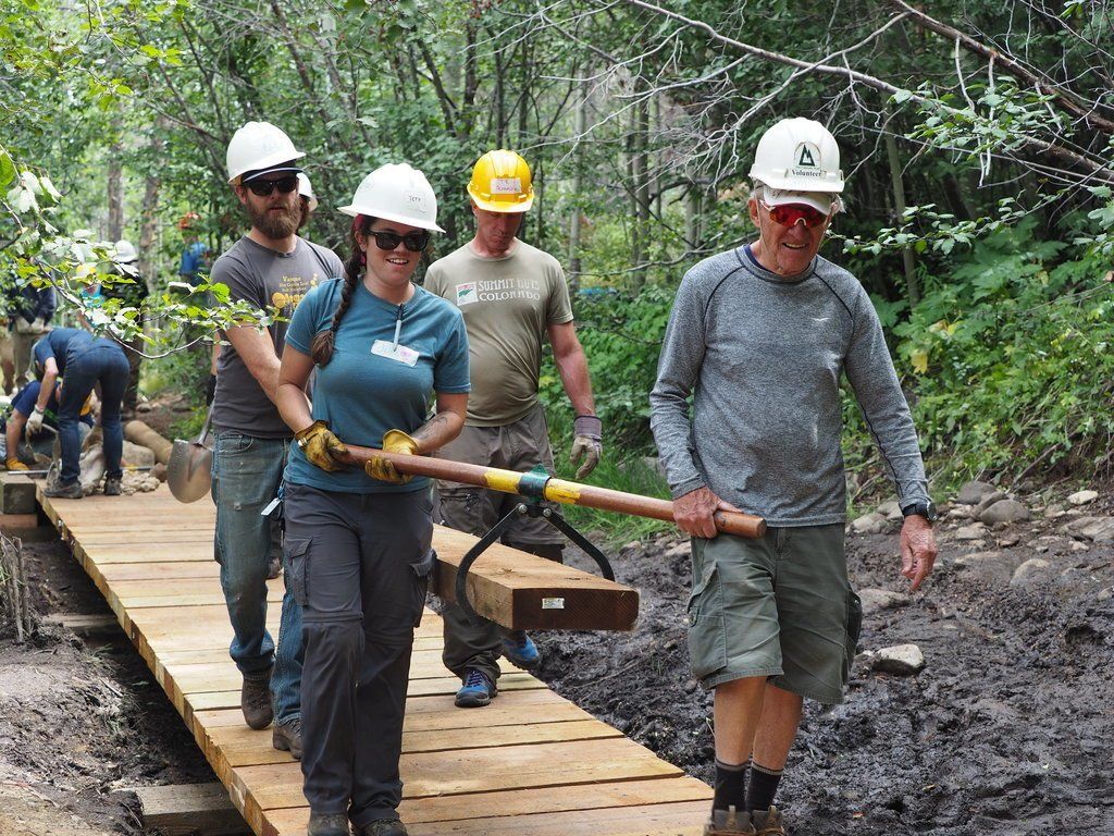 VOC volunteers carry a wood plank