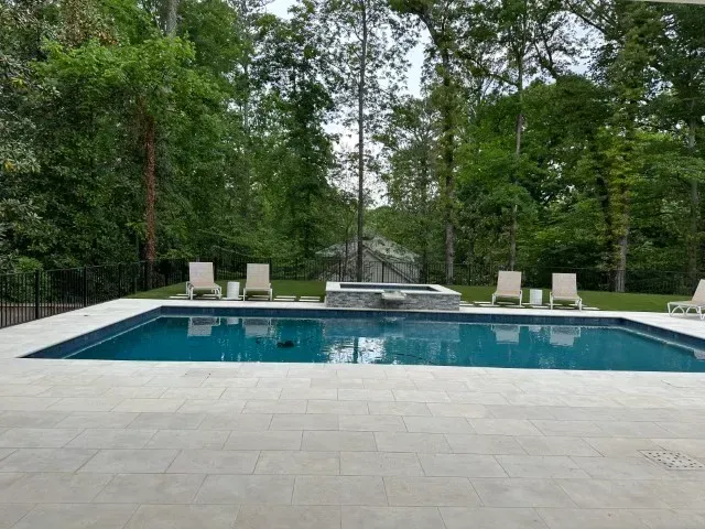 White mansion with a grand staircase, set in lush greenery.