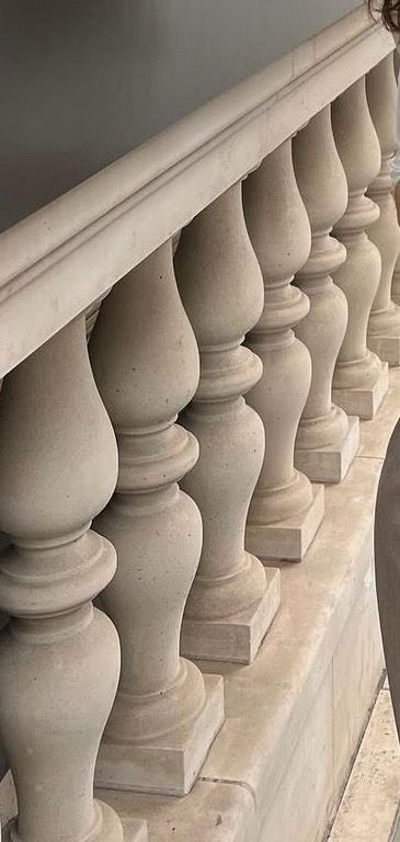 Stone balustrade, close-up. Beige pillars with rounded tops and square bases.
