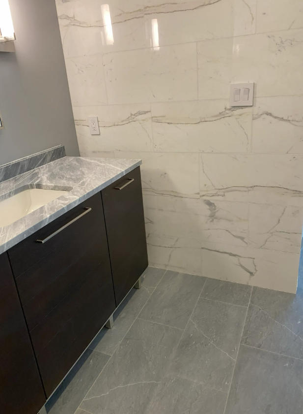 White mansion with a grand staircase, set in lush greenery.