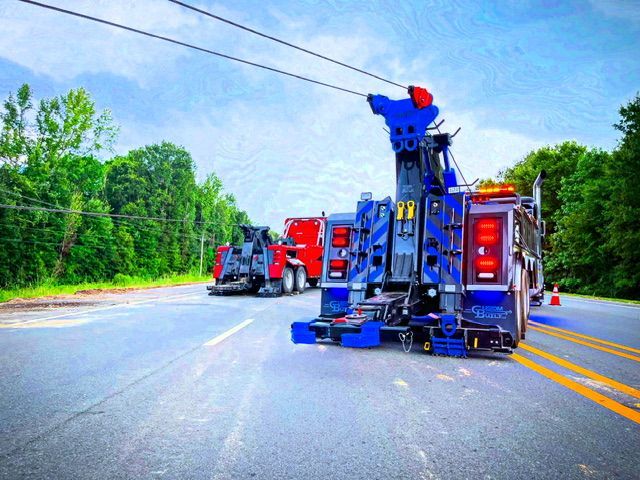 A purple tow truck is parked on the side of the road.