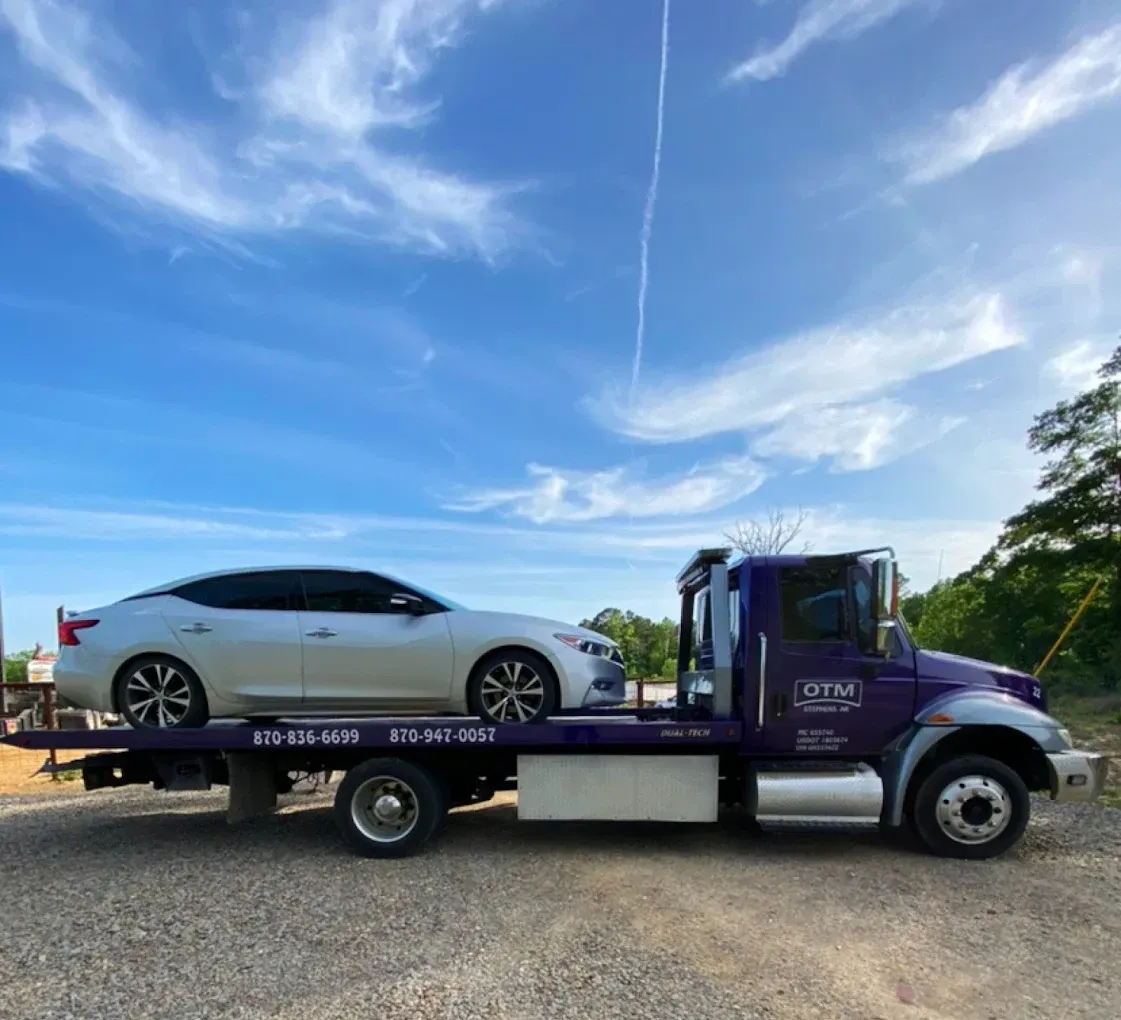A tow truck with a car on the back of it