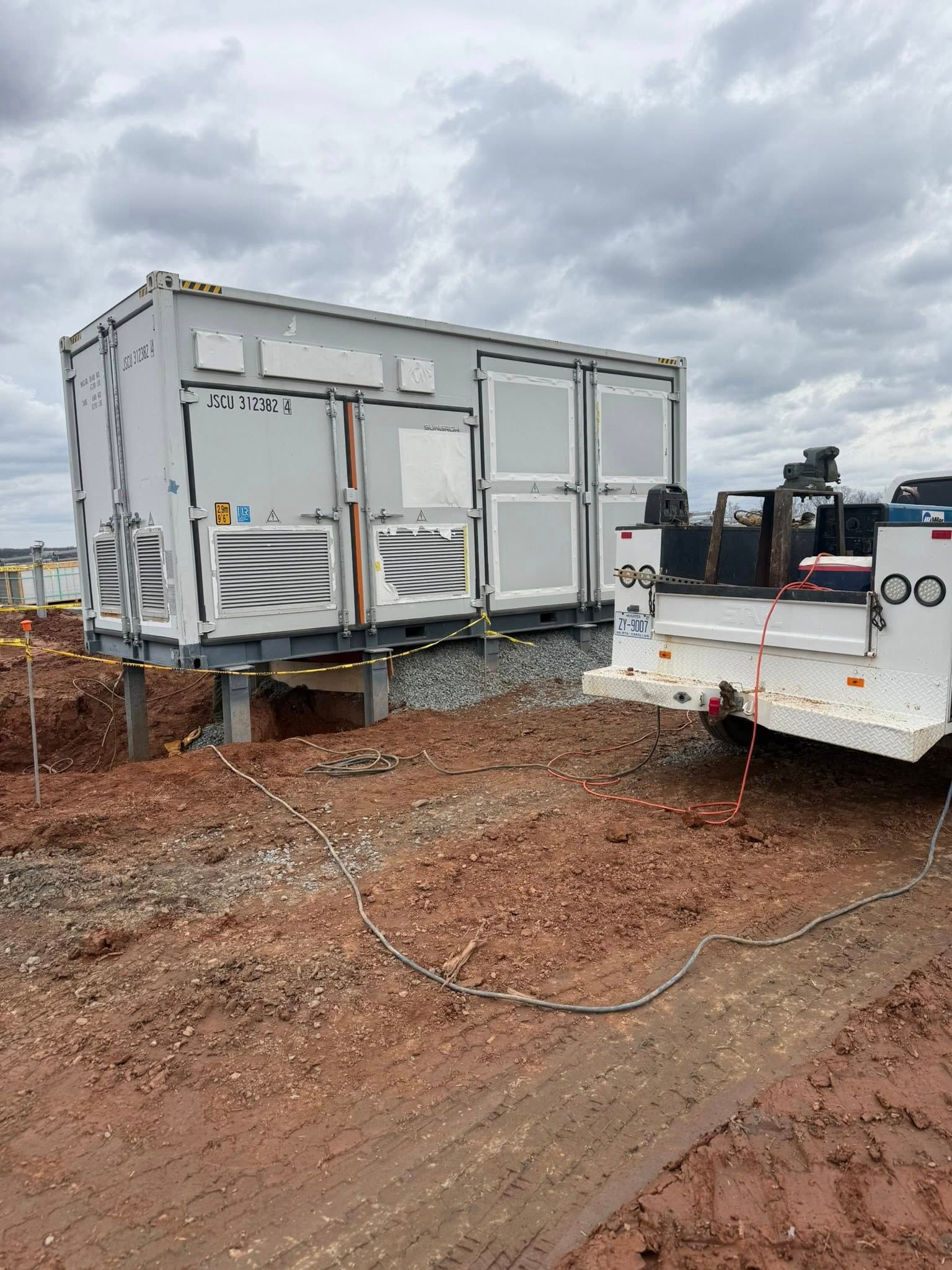 A long metal pipe being worked on in a garage, supported by a pipe stand.