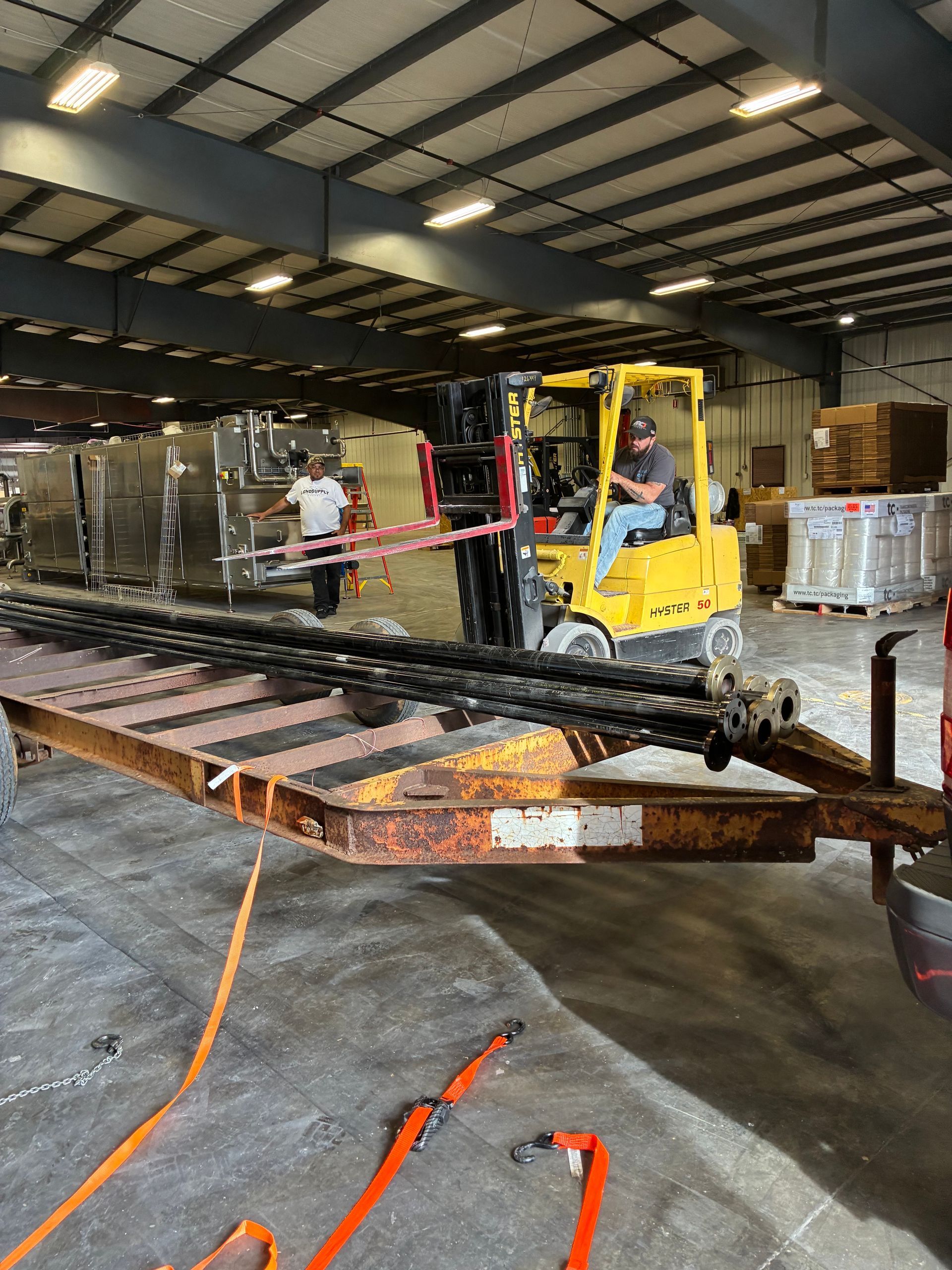 A metal plate held in a vise with metal strips attached. A rusty metal case is in the background.