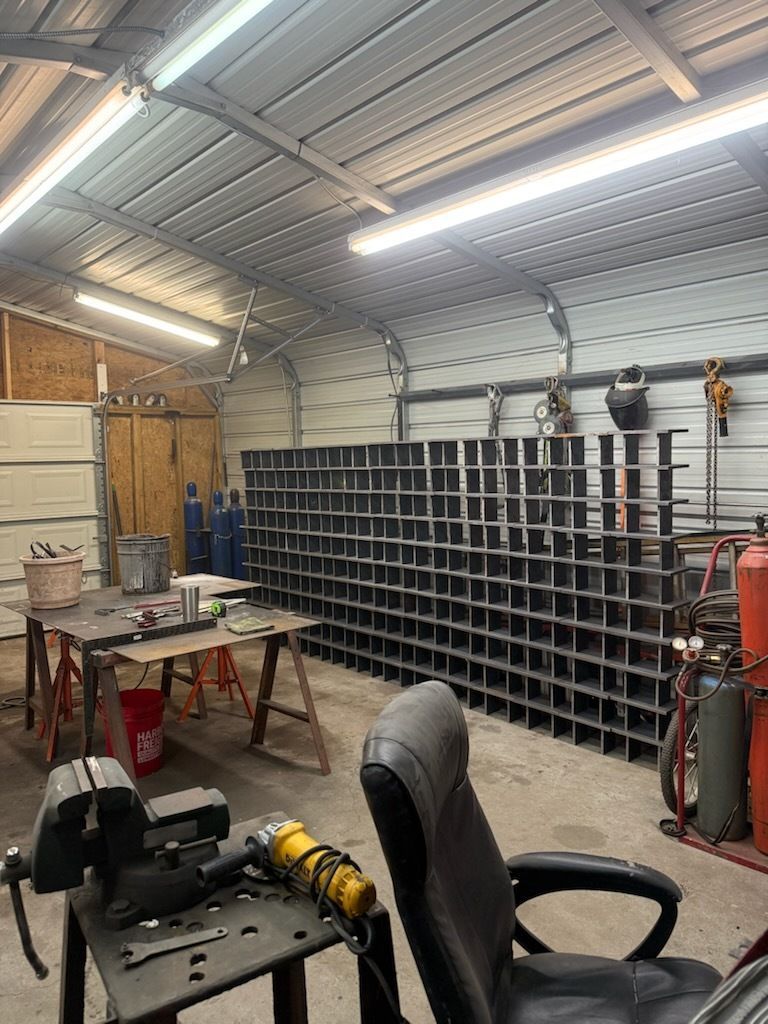 Workshop interior with metal shelving unit, welding equipment, and tools.