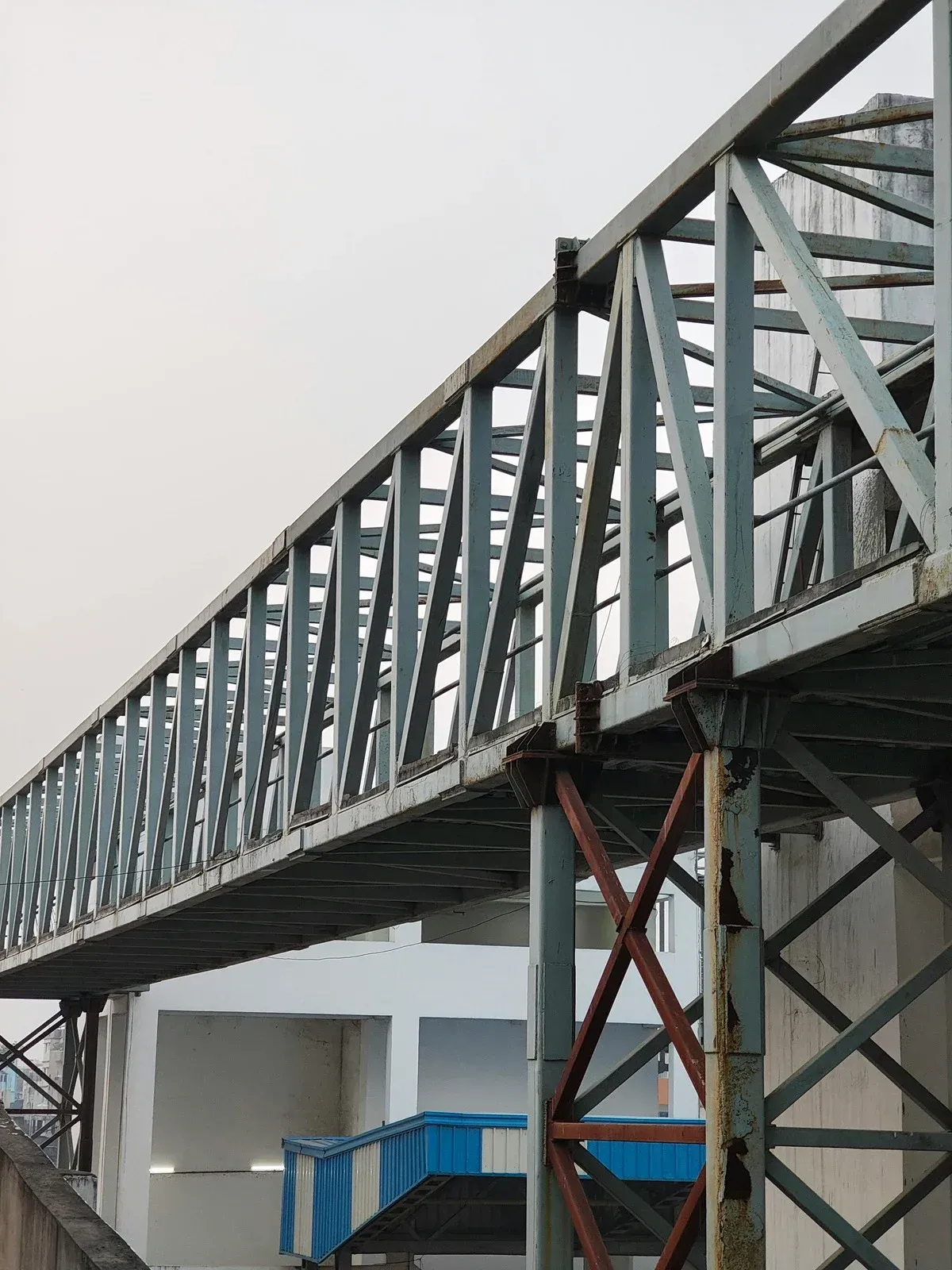 Solar panel installation on a rooftop: worker on a metal frame, panels installed, blue sky.