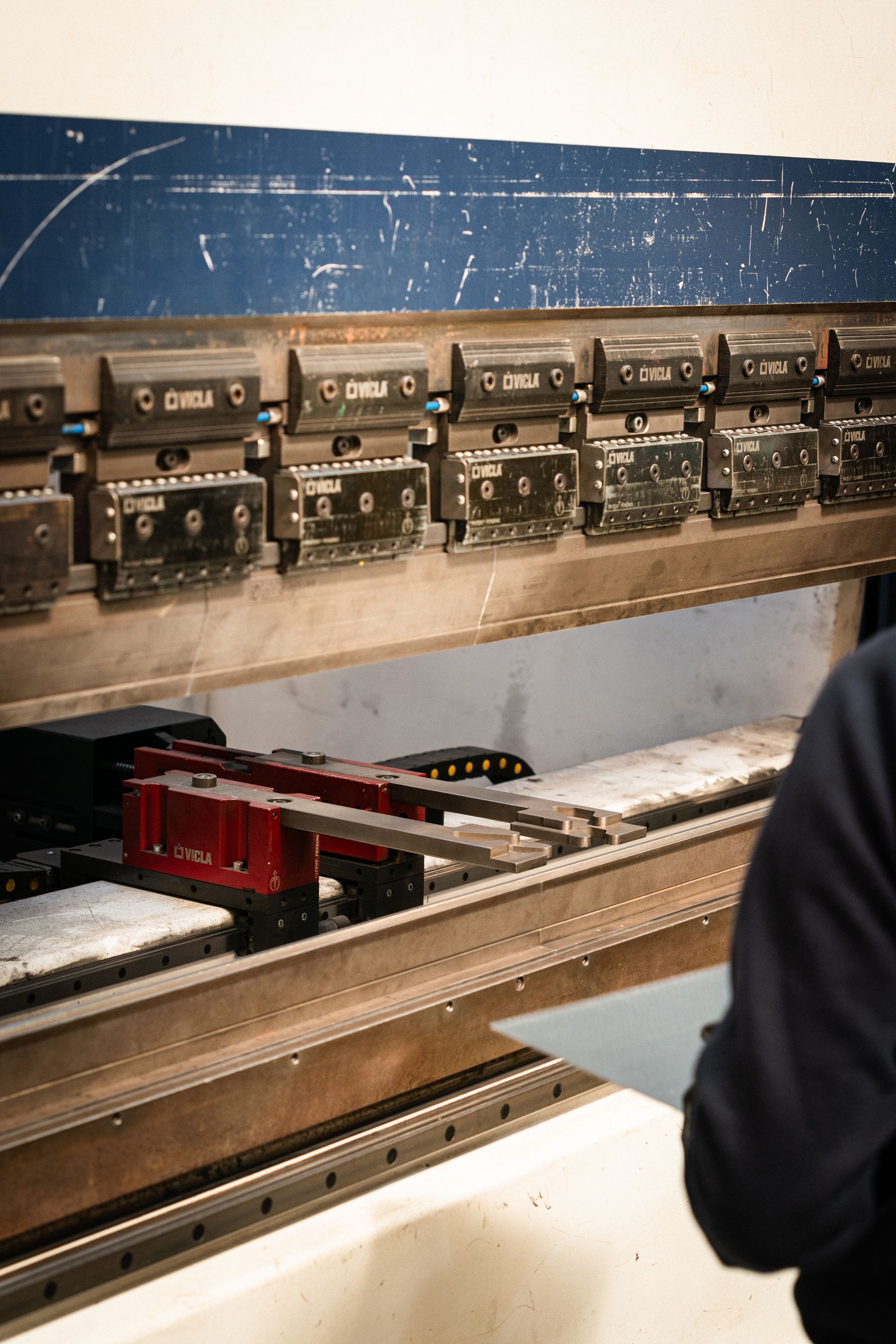 Lamiera piegata da una pressa idraulica, ambiente industriale.