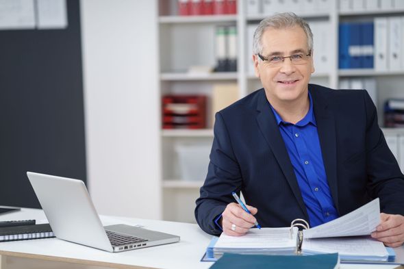 Ein Mann und eine Frau posieren in einem Büro für ein Foto.