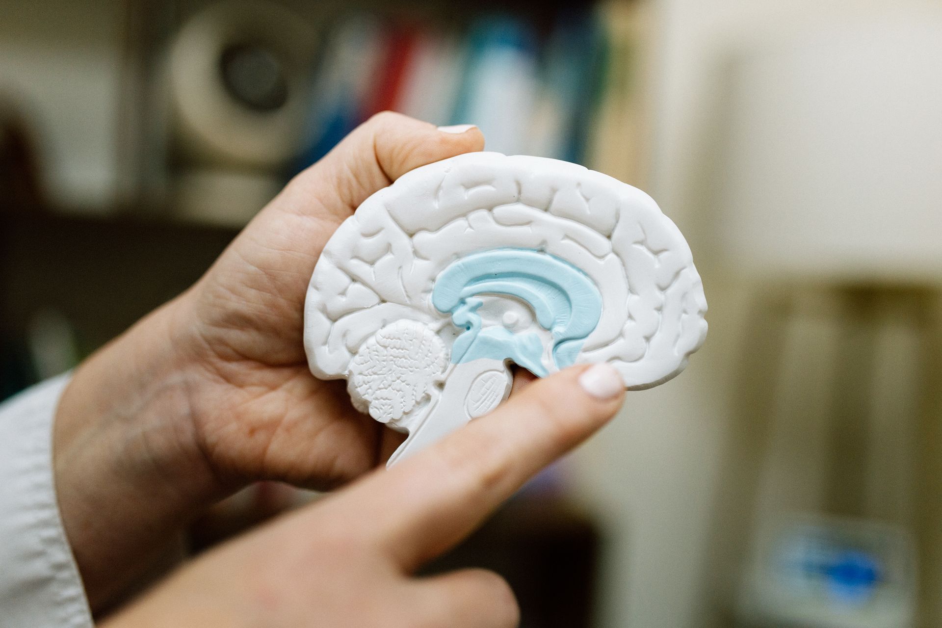 A woman is standing on a pier with her arms outstretched at sunset