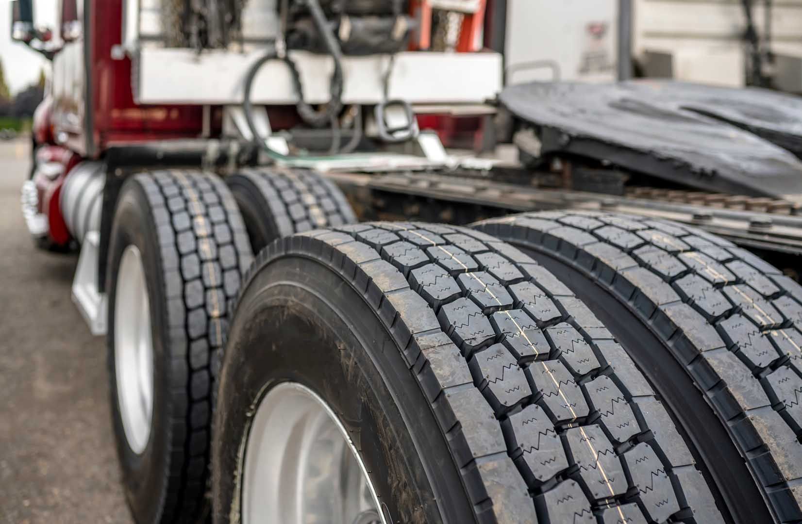 Close-up of semi-truck tires and wheels, focus on the tread pattern.