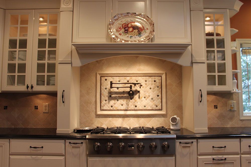 A kitchen with white cabinets and a stove top oven