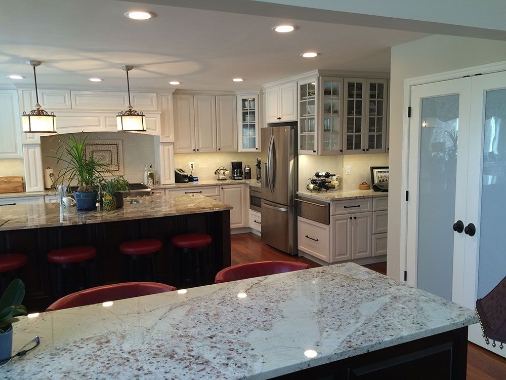 A kitchen with white cabinets and granite counter tops