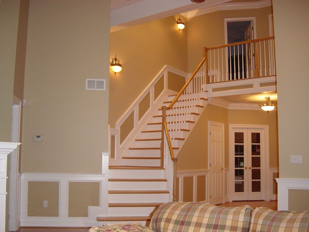 A living room with stairs leading up to the second floor