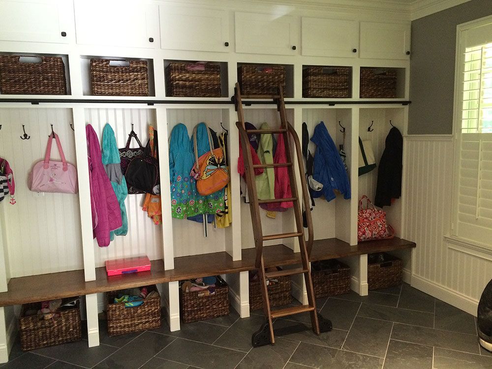 A mud room with a ladder and lots of baskets