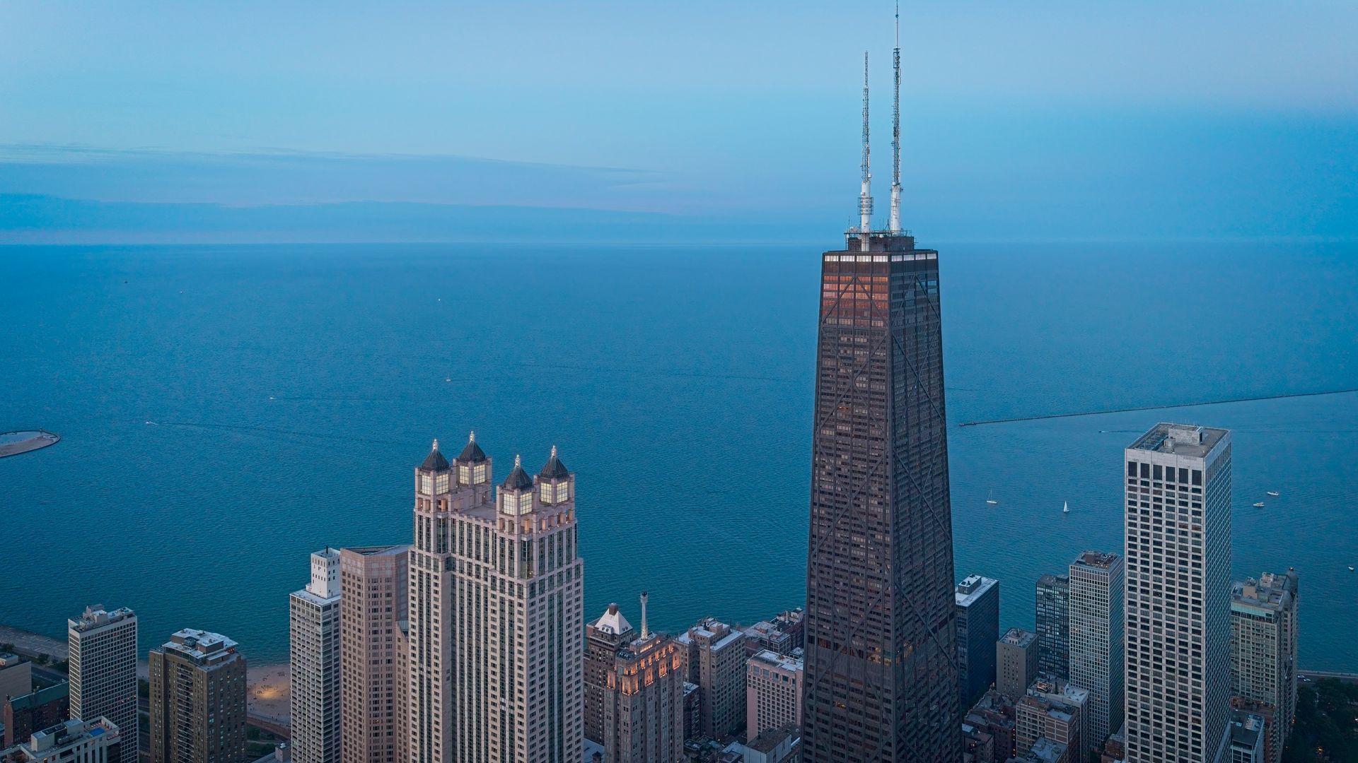 Chicago skyline with the John Hancock Center beside Lake Michigan under a hazy blue sky