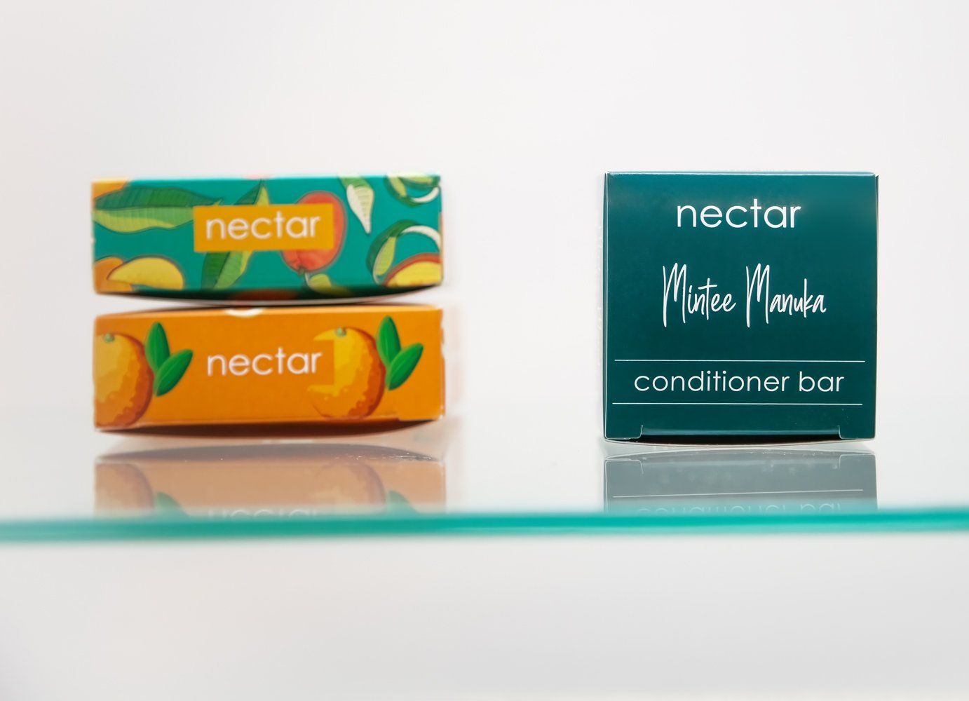 Two soap bars stacked, orange & teal packaging. The label reads 