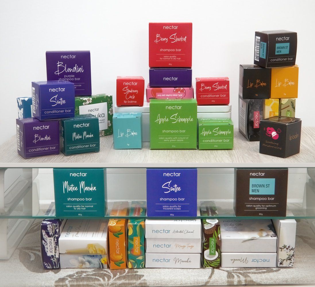 Display of colorful cosmetic product boxes on glass shelves. From Excel In Print Auckland. 