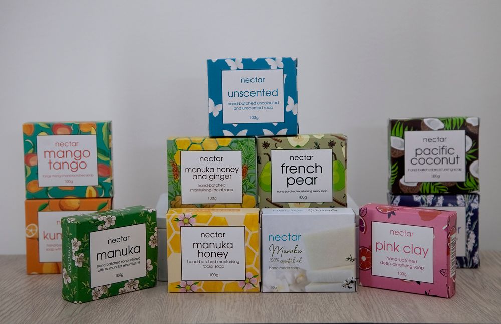 Boxes of scented soap, various flavors, stacked on a white surface.