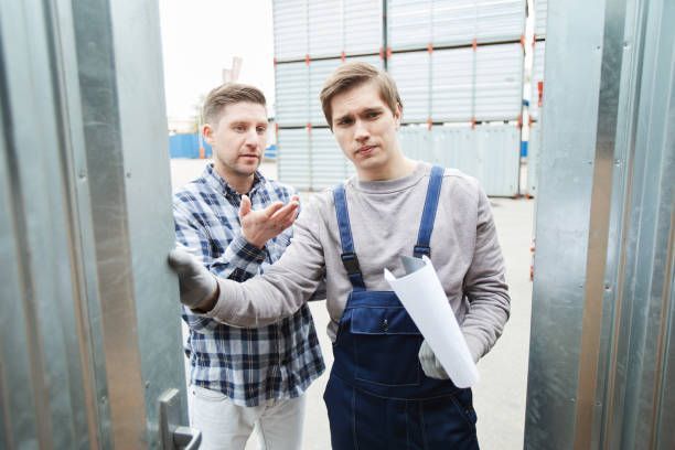 Person in overalls holding a blueprint