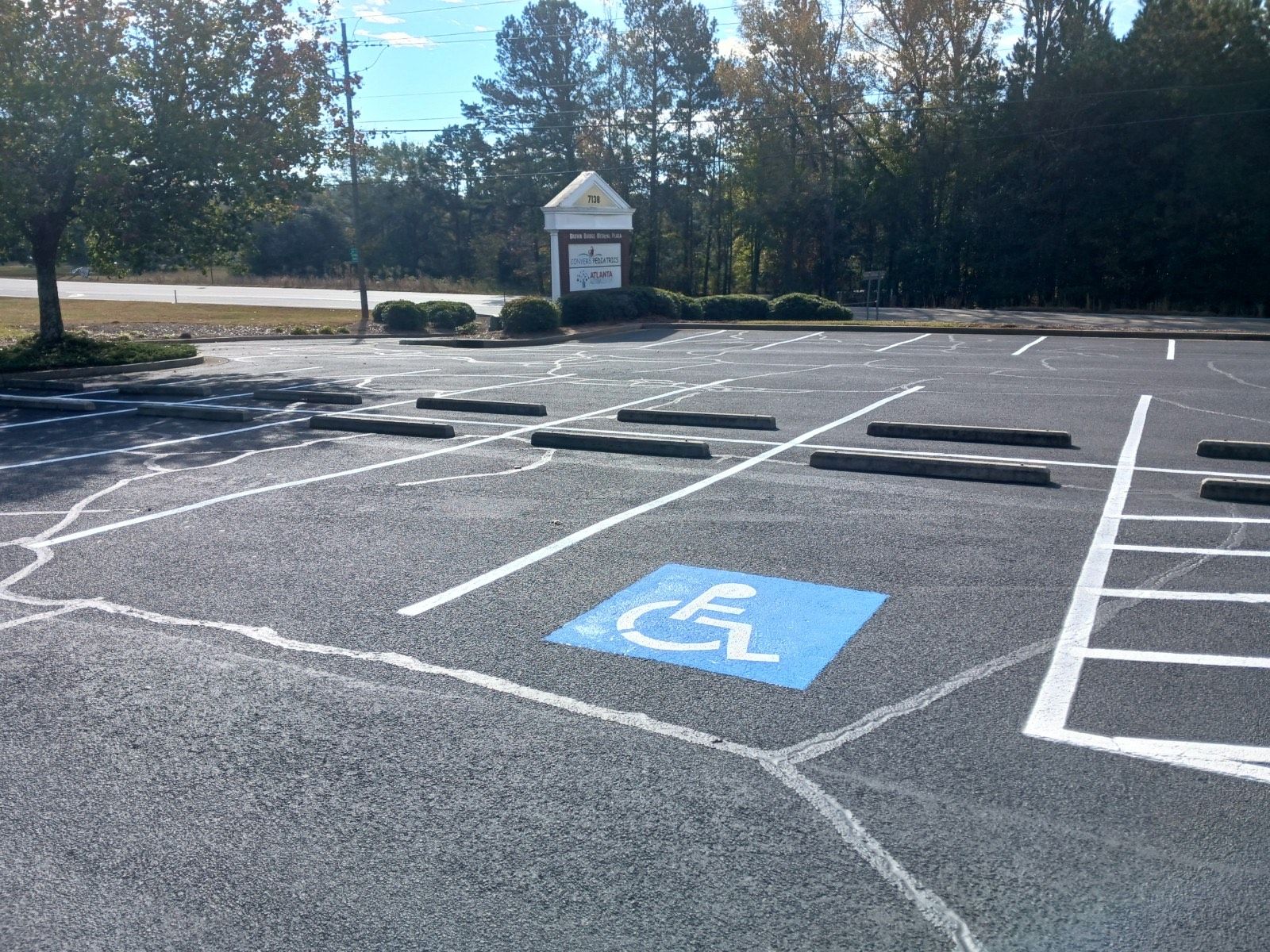 Empty asphalt parking lot with white painted lines for parking spaces.