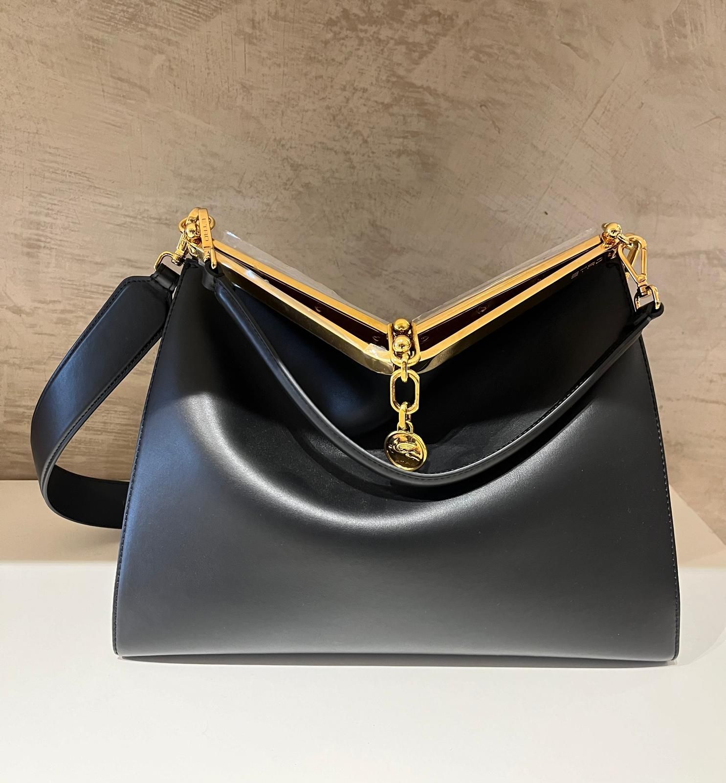 Una borsa marrone con un cinturino nero è appoggiata su un tavolo bianco.