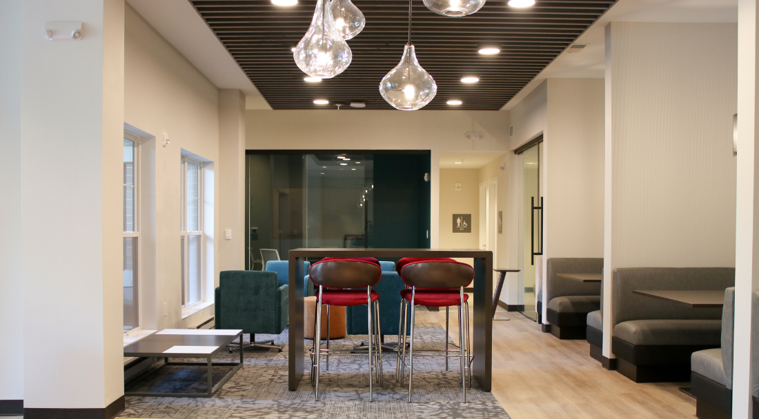 Study area with seating, tables, pendant lights, and wood ceiling.