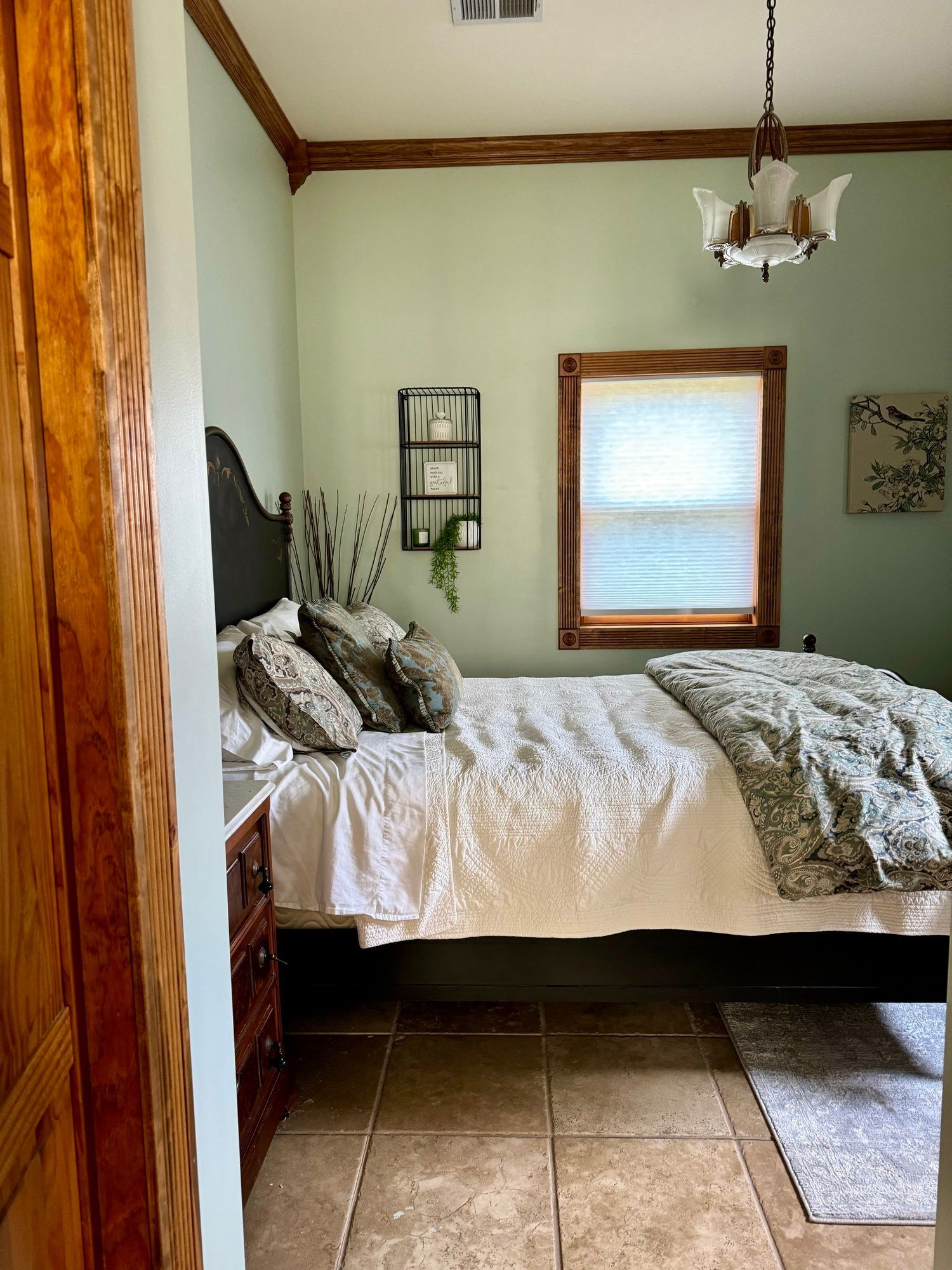 A bedroom with a bed , nightstand , and window.