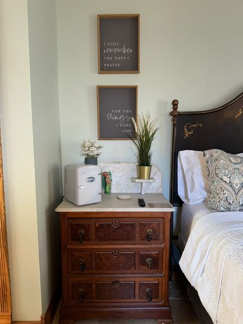 A bedroom with a dresser and a bed