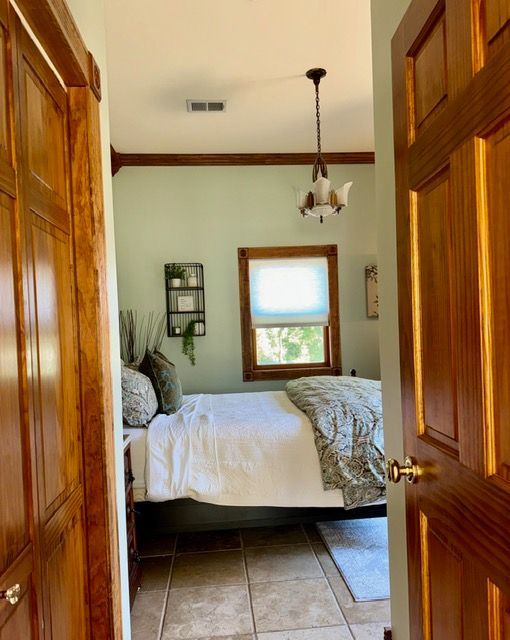A bedroom with a bed and a chandelier hanging from the ceiling