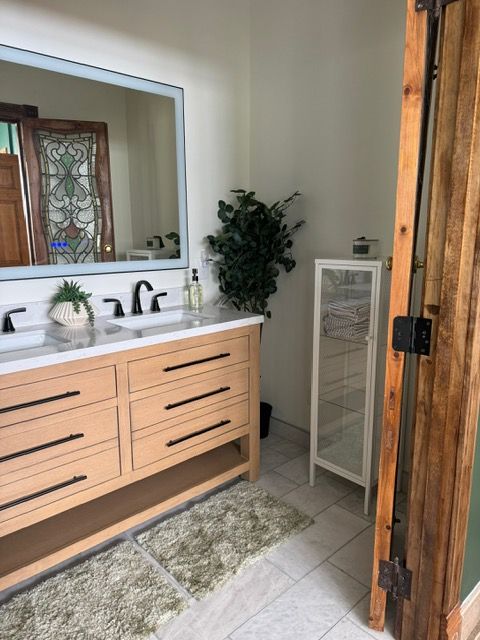 A bathroom with two sinks and a large mirror