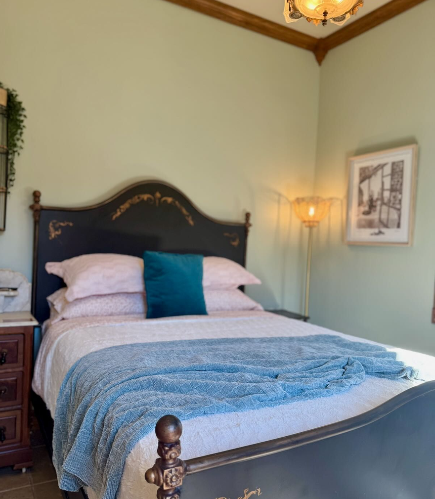A bedroom with a bed , dresser , and window.