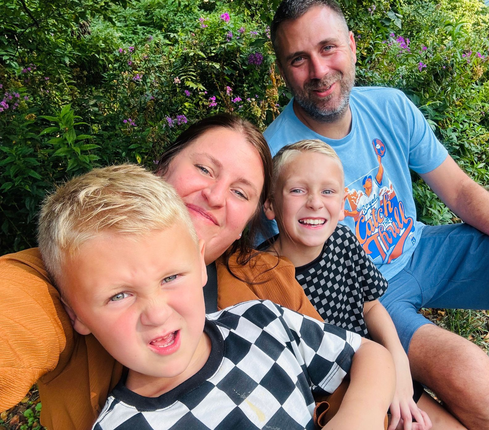 Two dogs are sitting in the grass in a field.