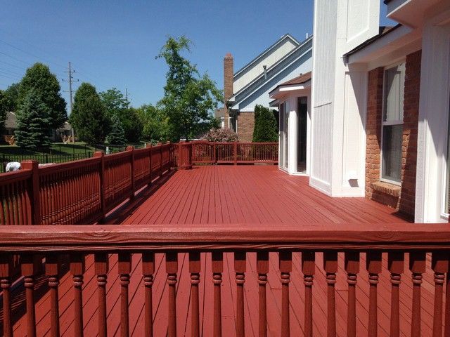 A red deck with a white house in the background