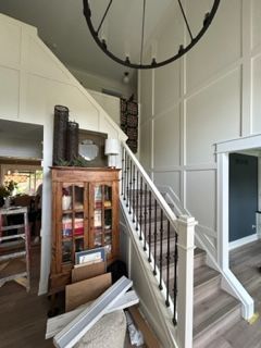 A staircase in a house with a chandelier hanging from the ceiling.