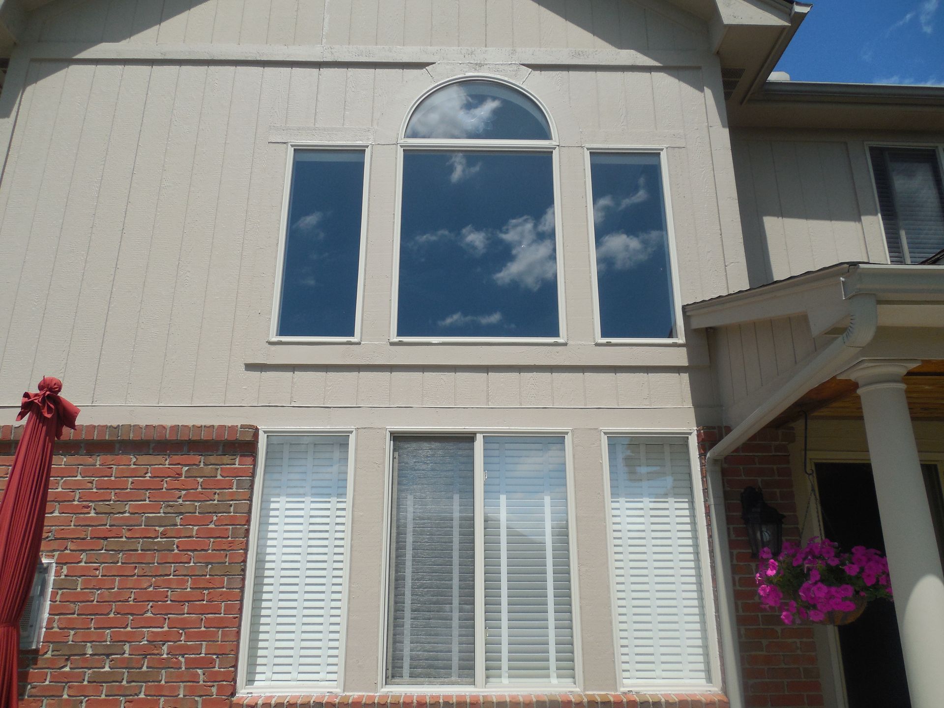 A house with a lot of windows and a red umbrella