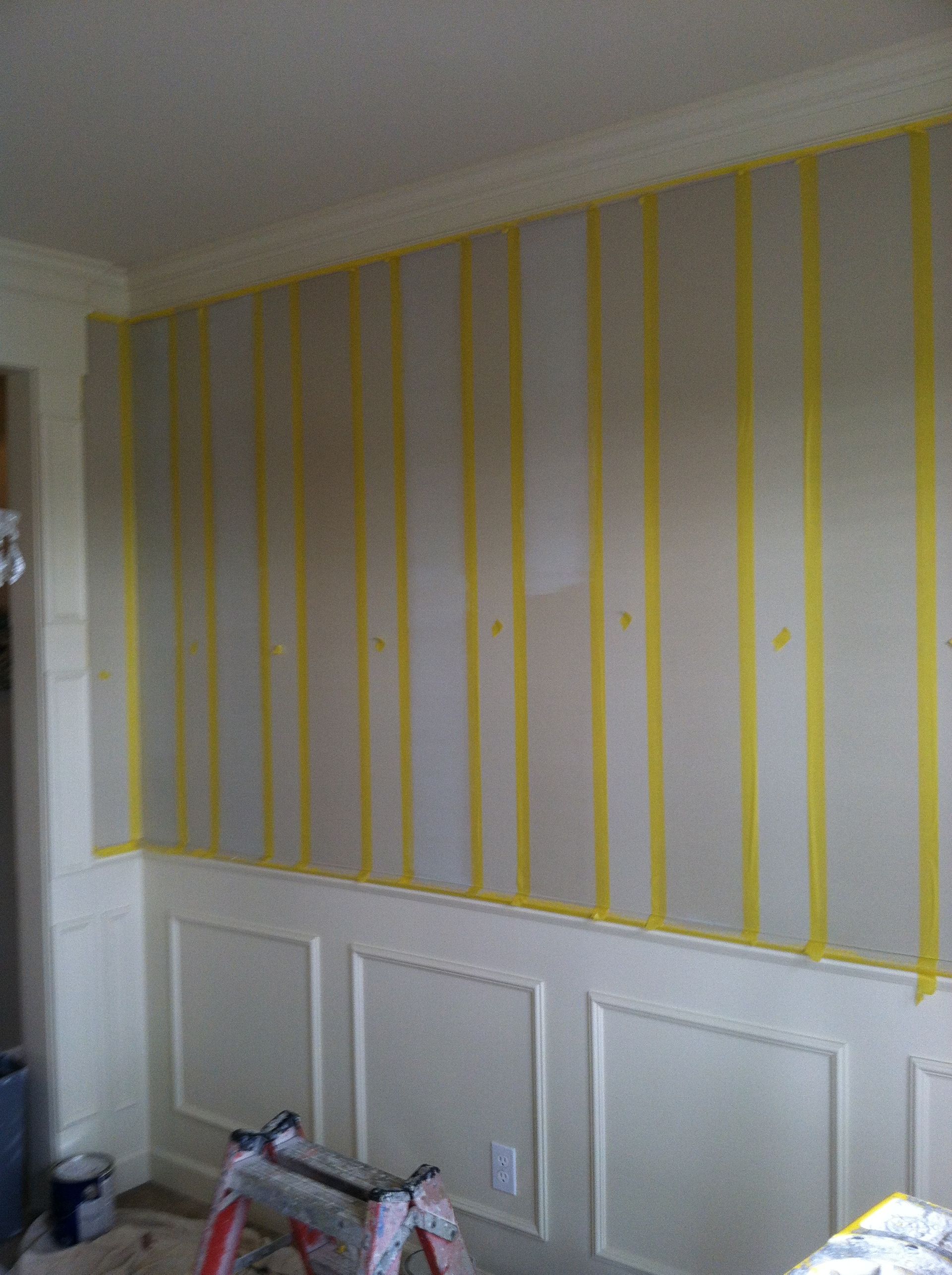A room with a ladder and a wall with yellow tape on it.