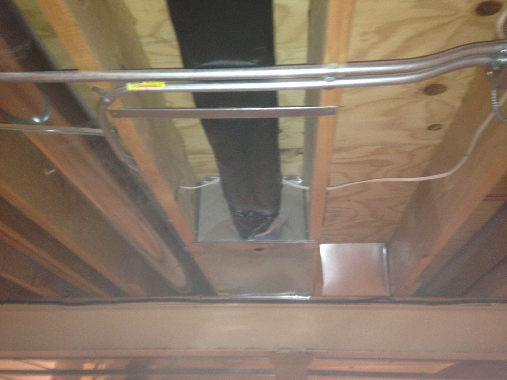 A pipe is hanging from the ceiling of a building.