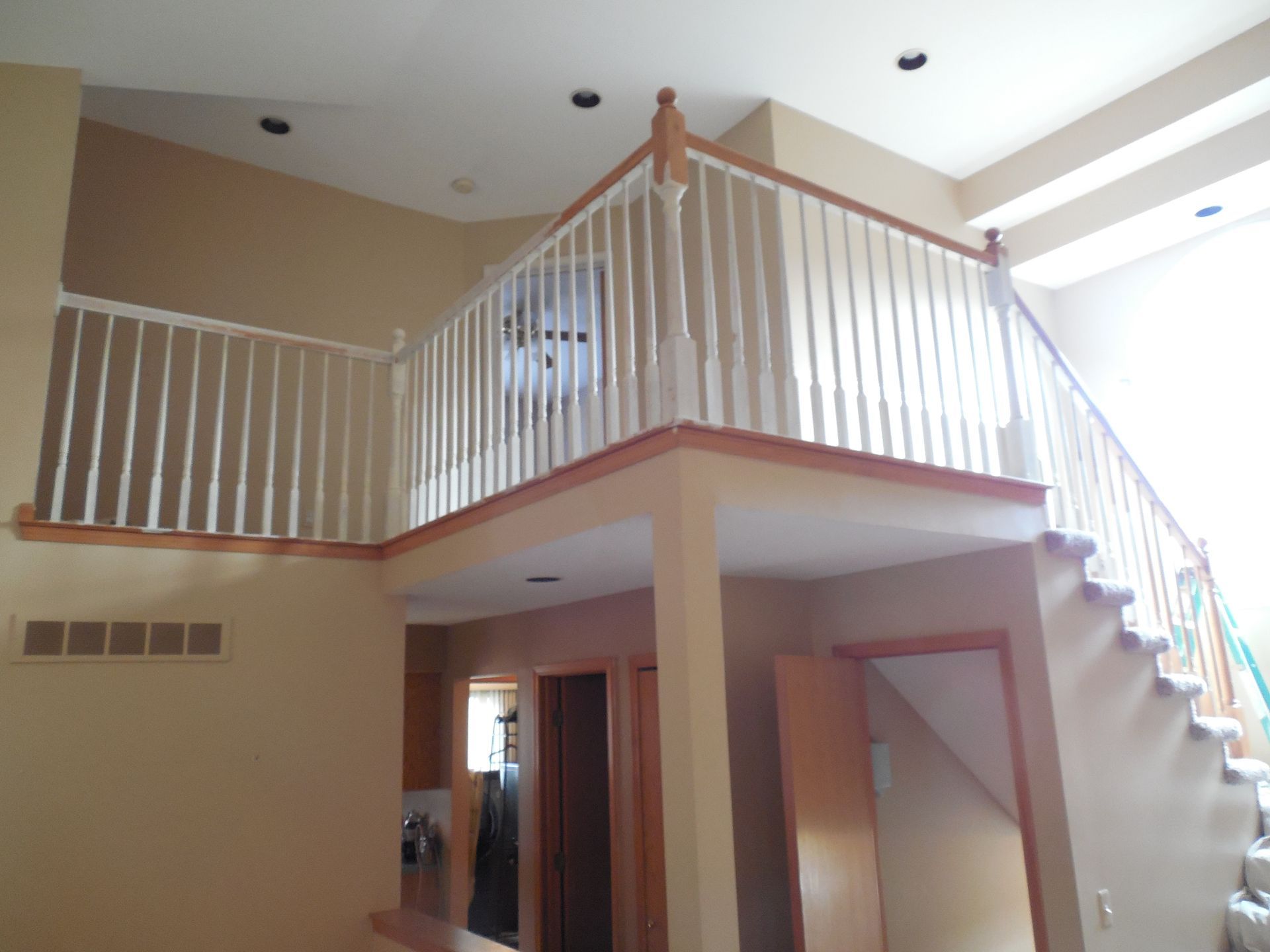 A staircase leading up to a loft with a white railing