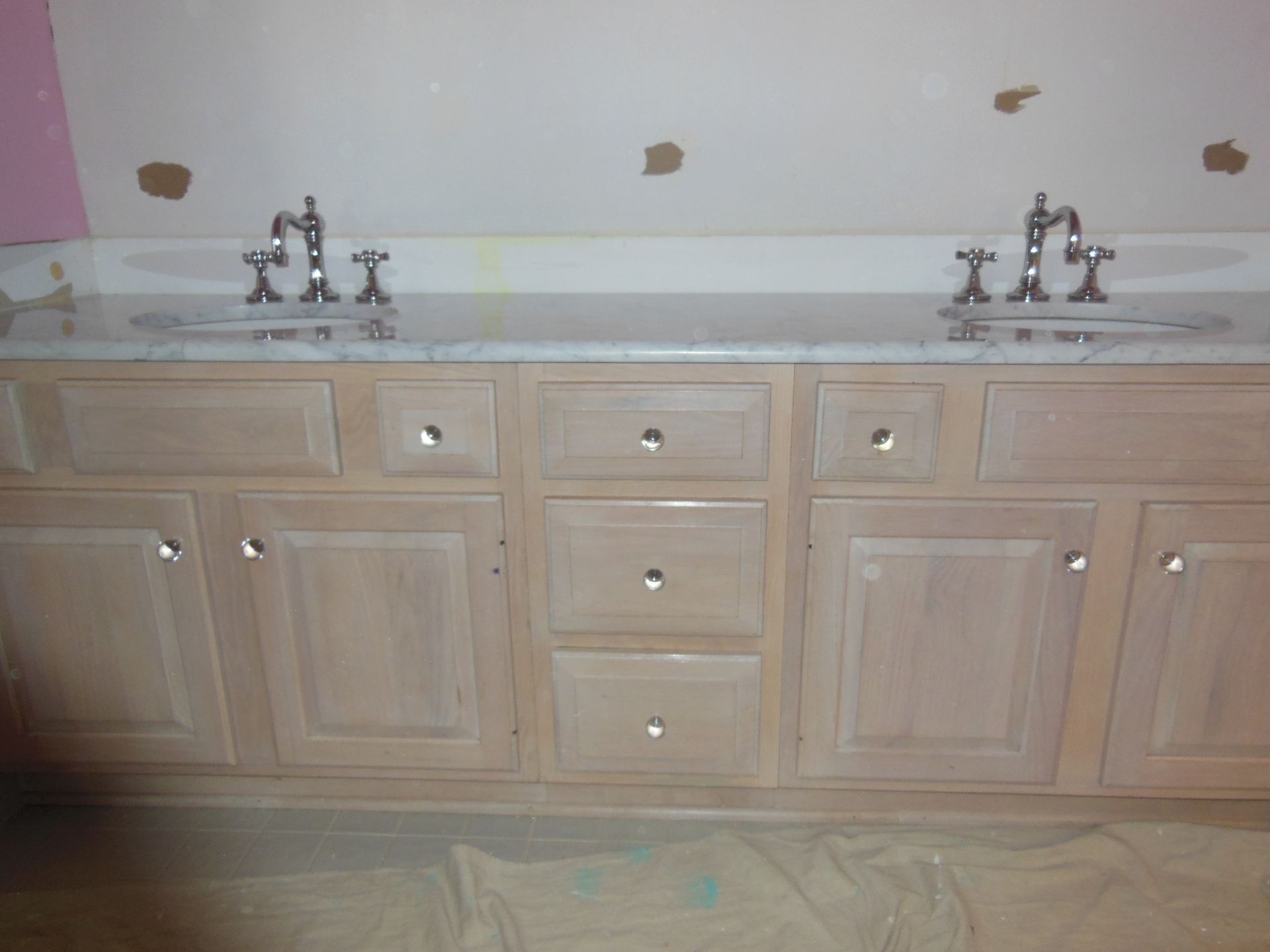 A bathroom vanity with two sinks and drawers
