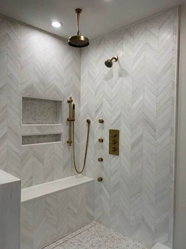 There is a shower with a bench and a shower head.