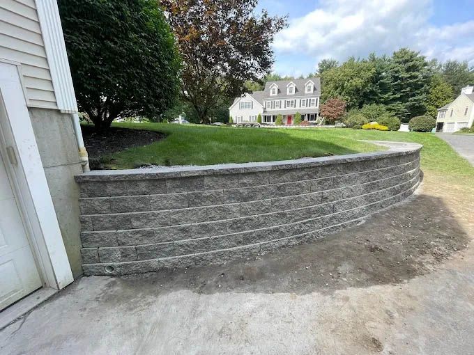 A brick wall is being built in front of a house.
