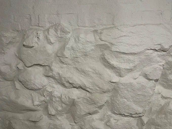 A close up of a stone wall with a lot of white powder on it.