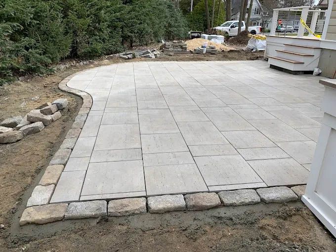 A patio is being built in the backyard of a house.