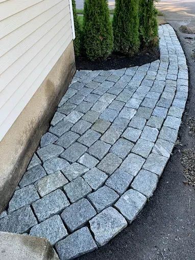 A brick walkway is being built in front of a house.