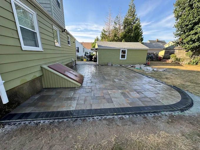 A patio is being built in the backyard of a house.