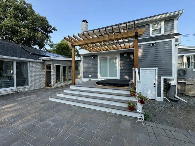 A house with a pergola and stairs in front of it