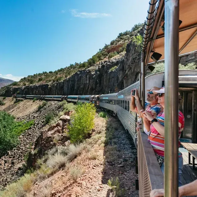 A group of people are riding on the back of a train.