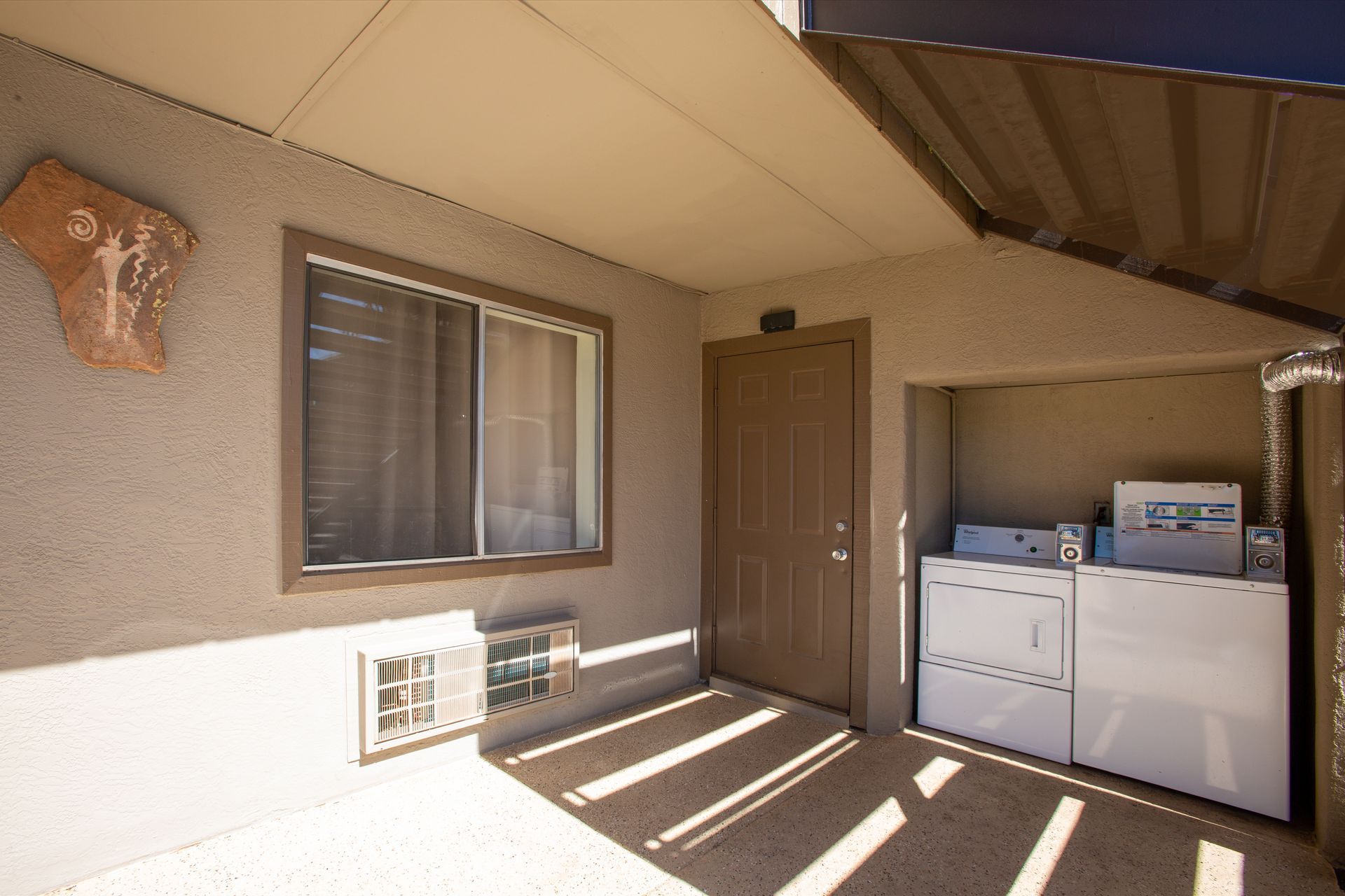 A laundry room with a washer and dryer and a window