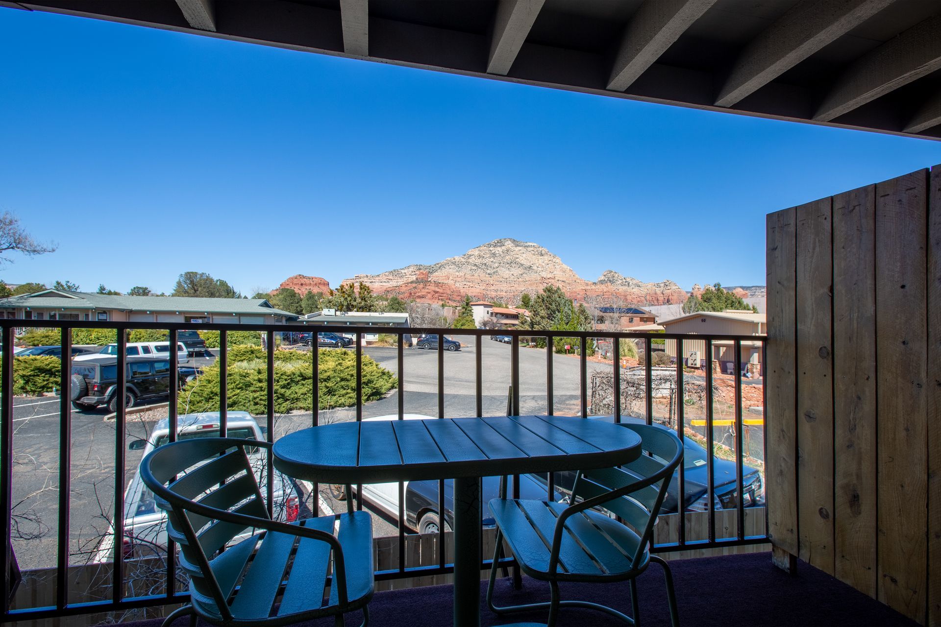 A balcony with a table and chairs and a view of a mountain