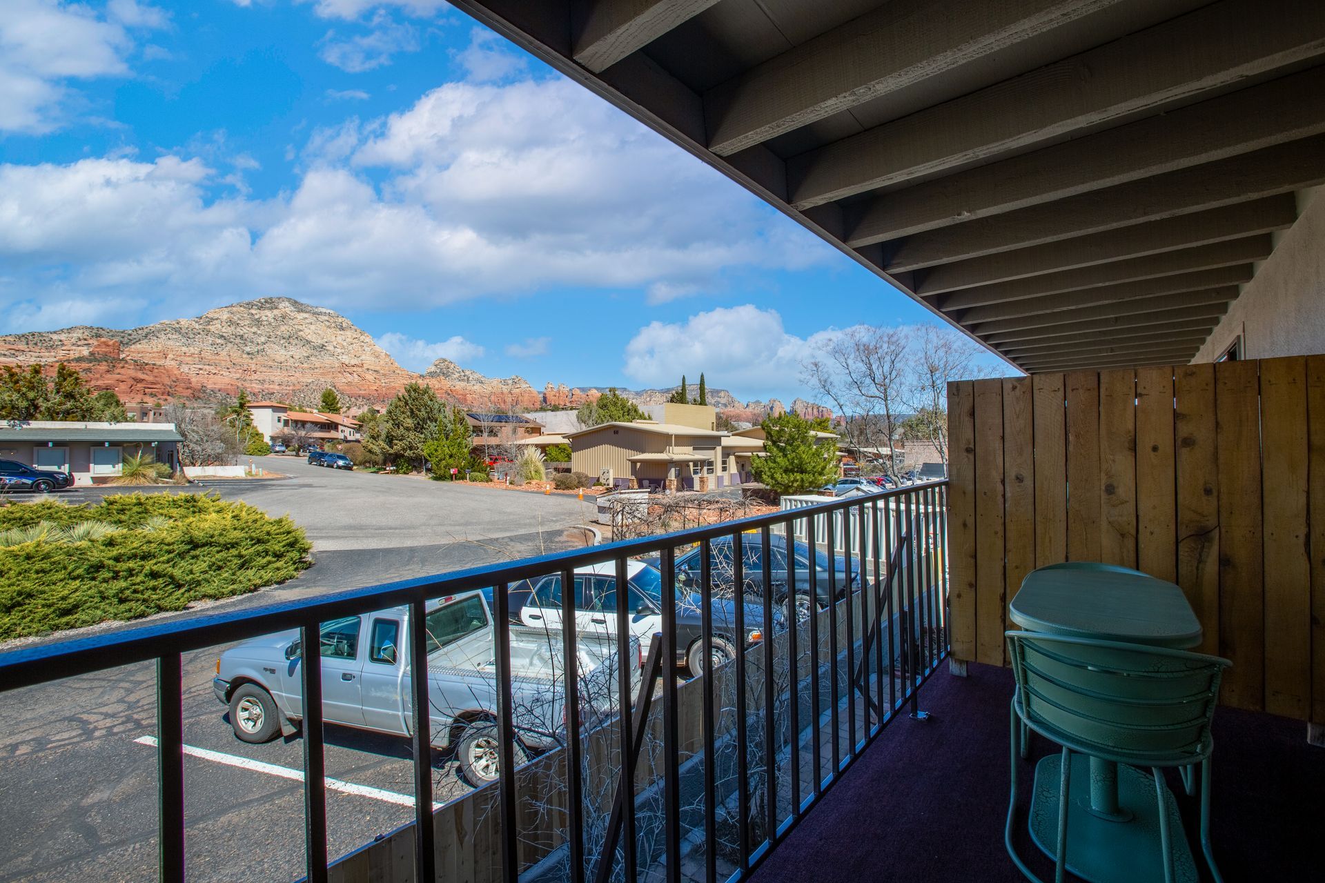 A balcony with a view of a parking lot and mountains.